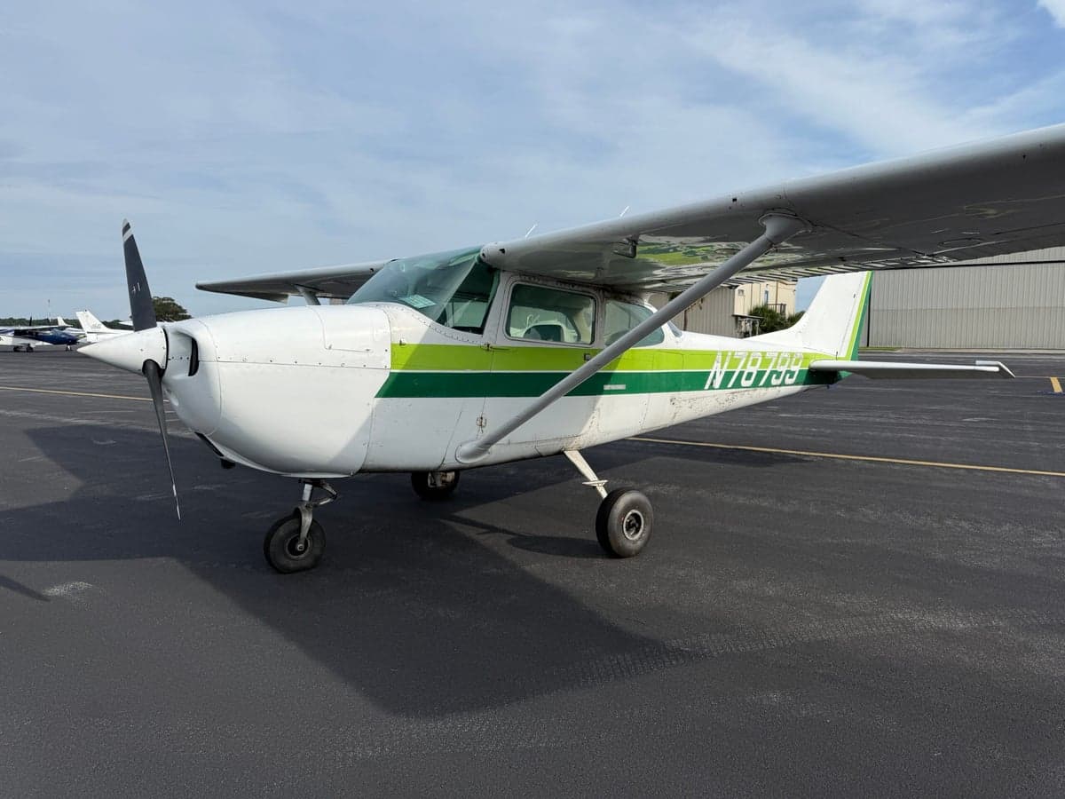 A Cessna 172 Skyhawk with green and white paint scheme parked on the tarmac.