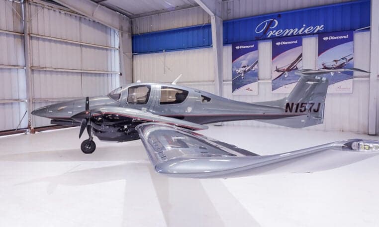 Diamond DA62 aircraft with tail number N157J in a hangar.