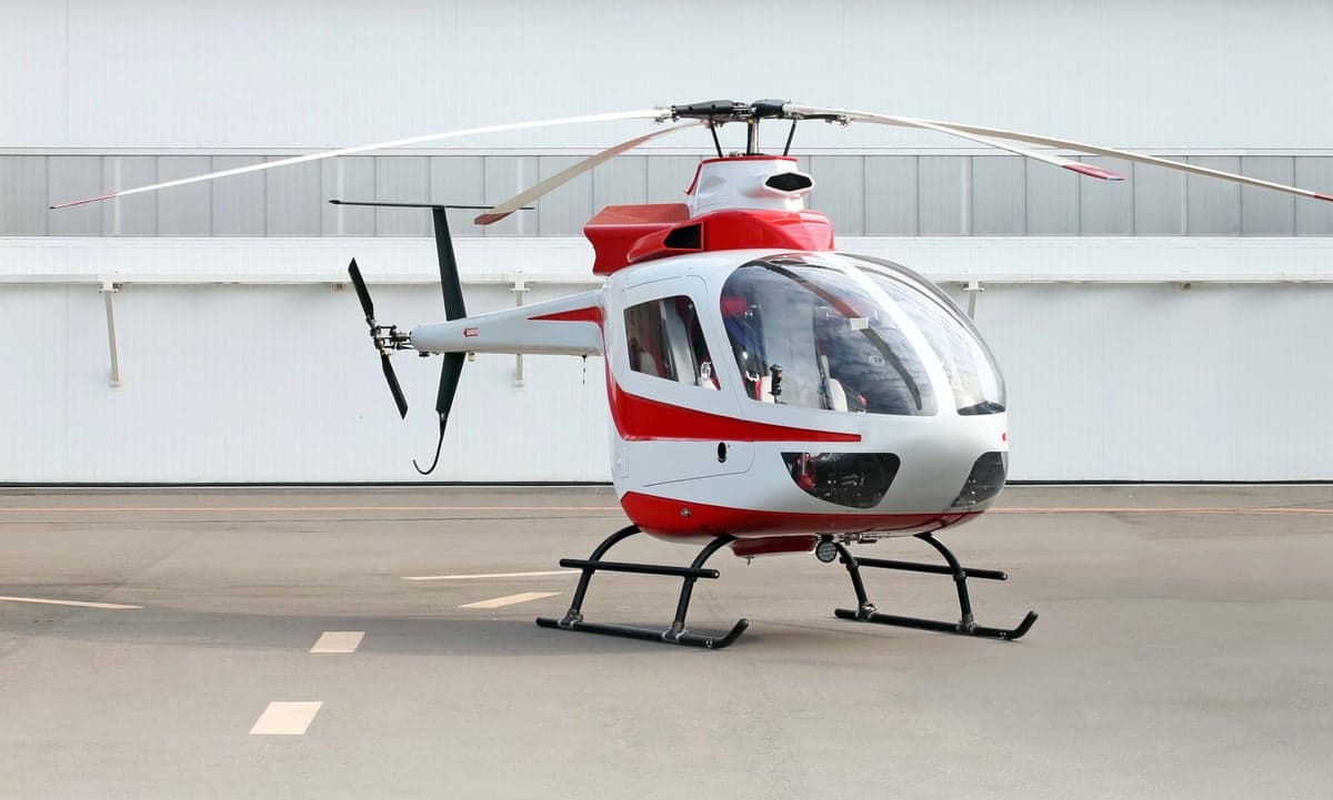 A front view of the white and red helicopter on the tarmac.