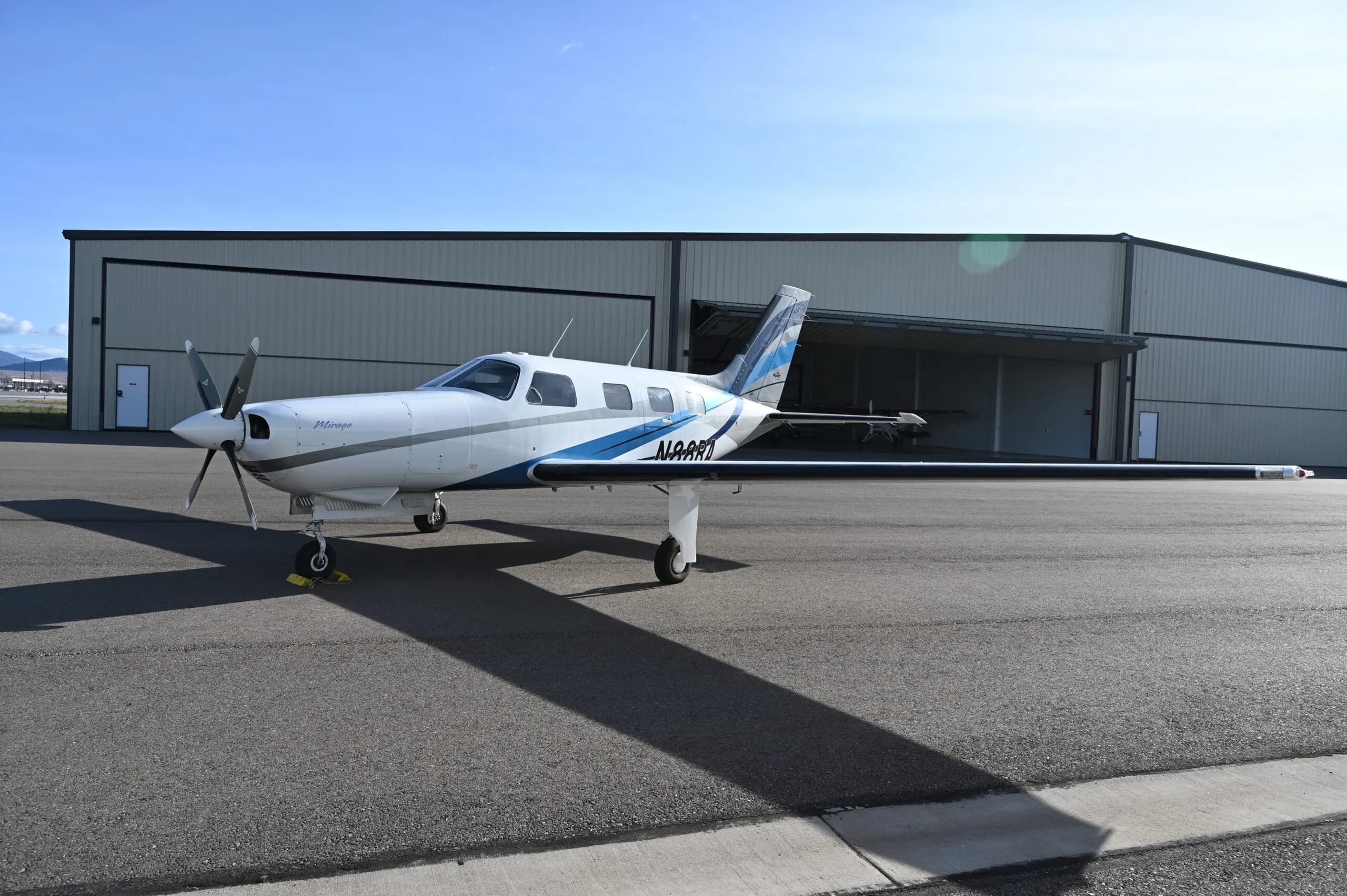 Piper Mirage N488RJ parked on the tarmac in front of a hangar.
