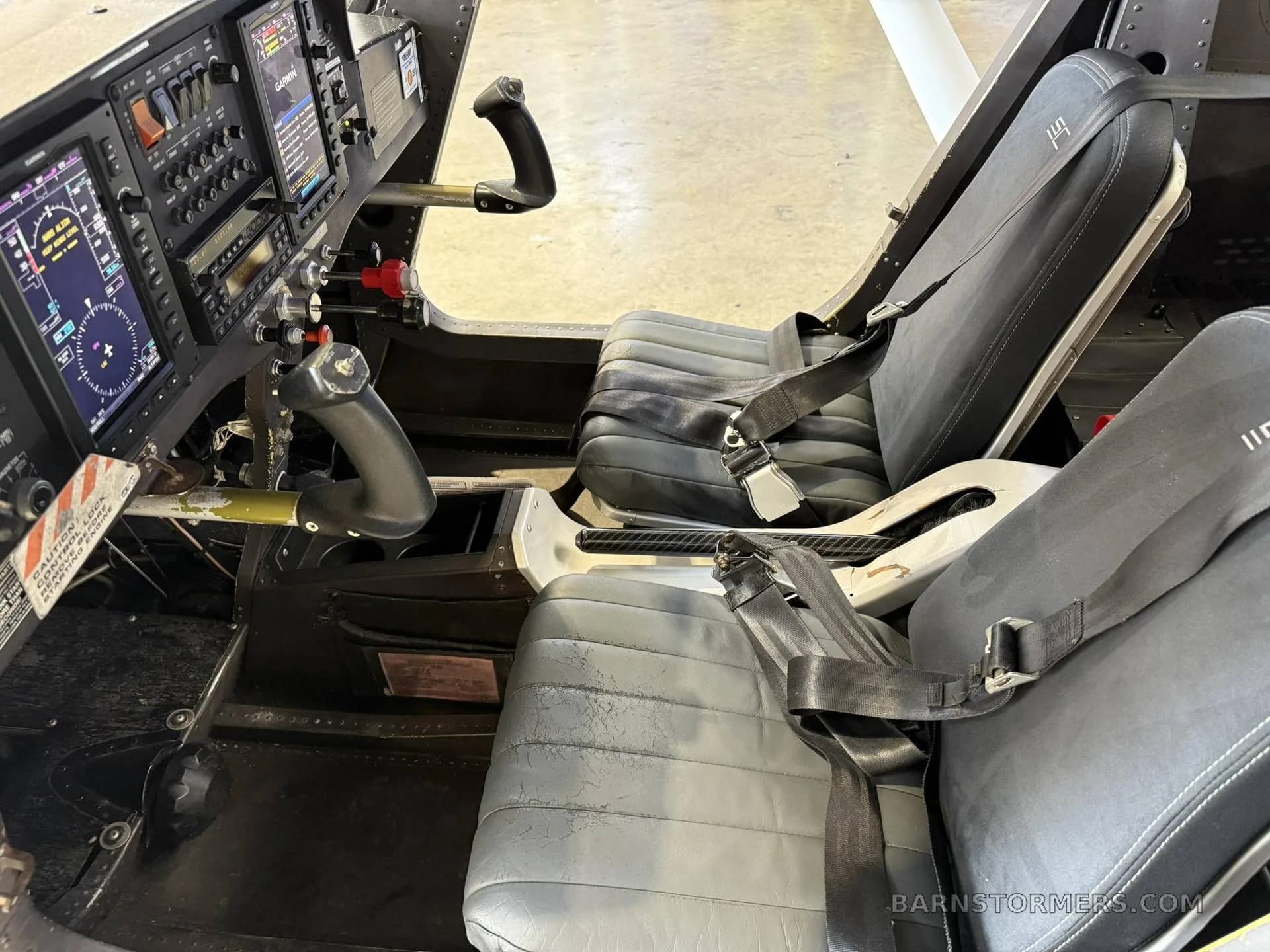 The interior of a Cessna Skycatcher, showing the cockpit with instrument panel and two grey pilot seats.