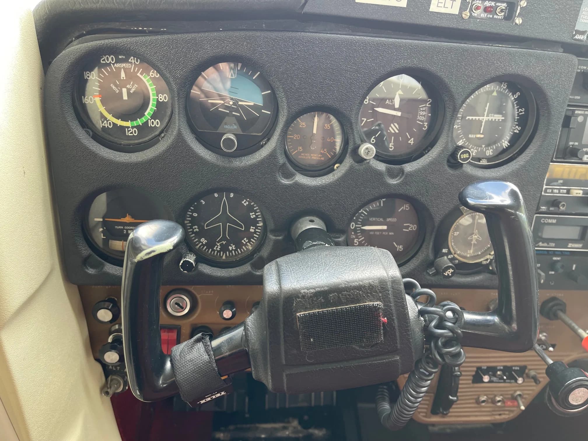 Aircraft cockpit instrument panel with flight controls.