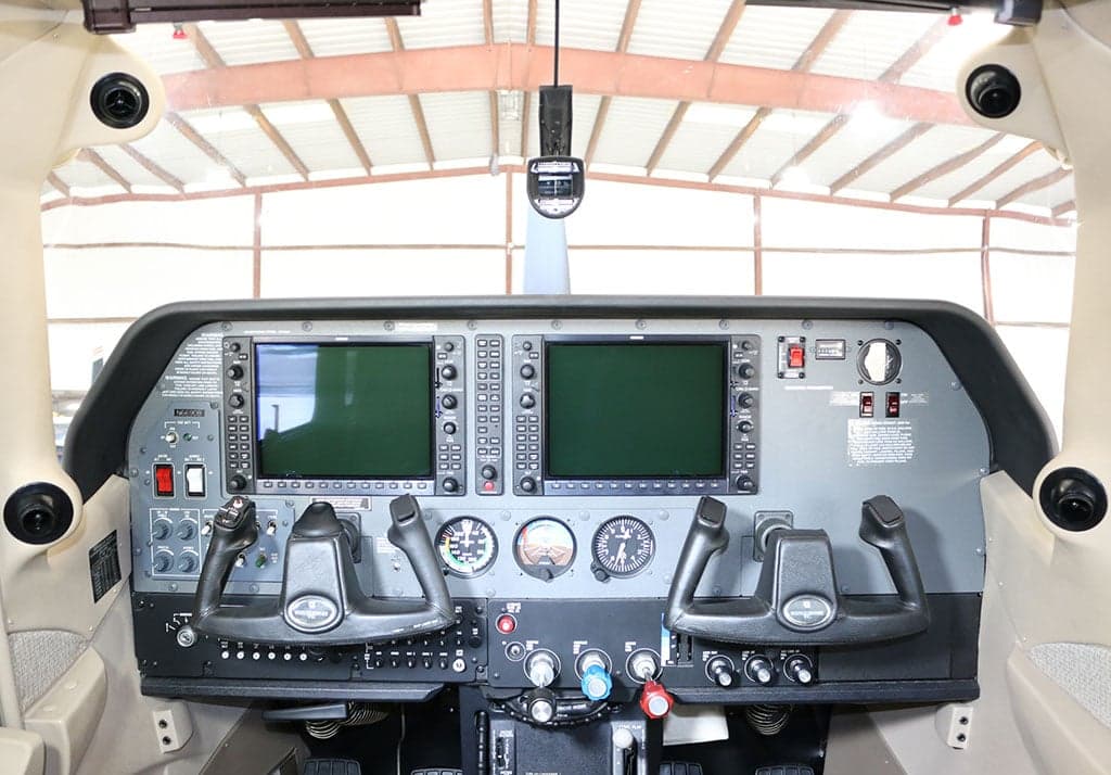 The cockpit of a Cessna Stationair TC, showing the instrument panel with two large display screens and dual yokes.