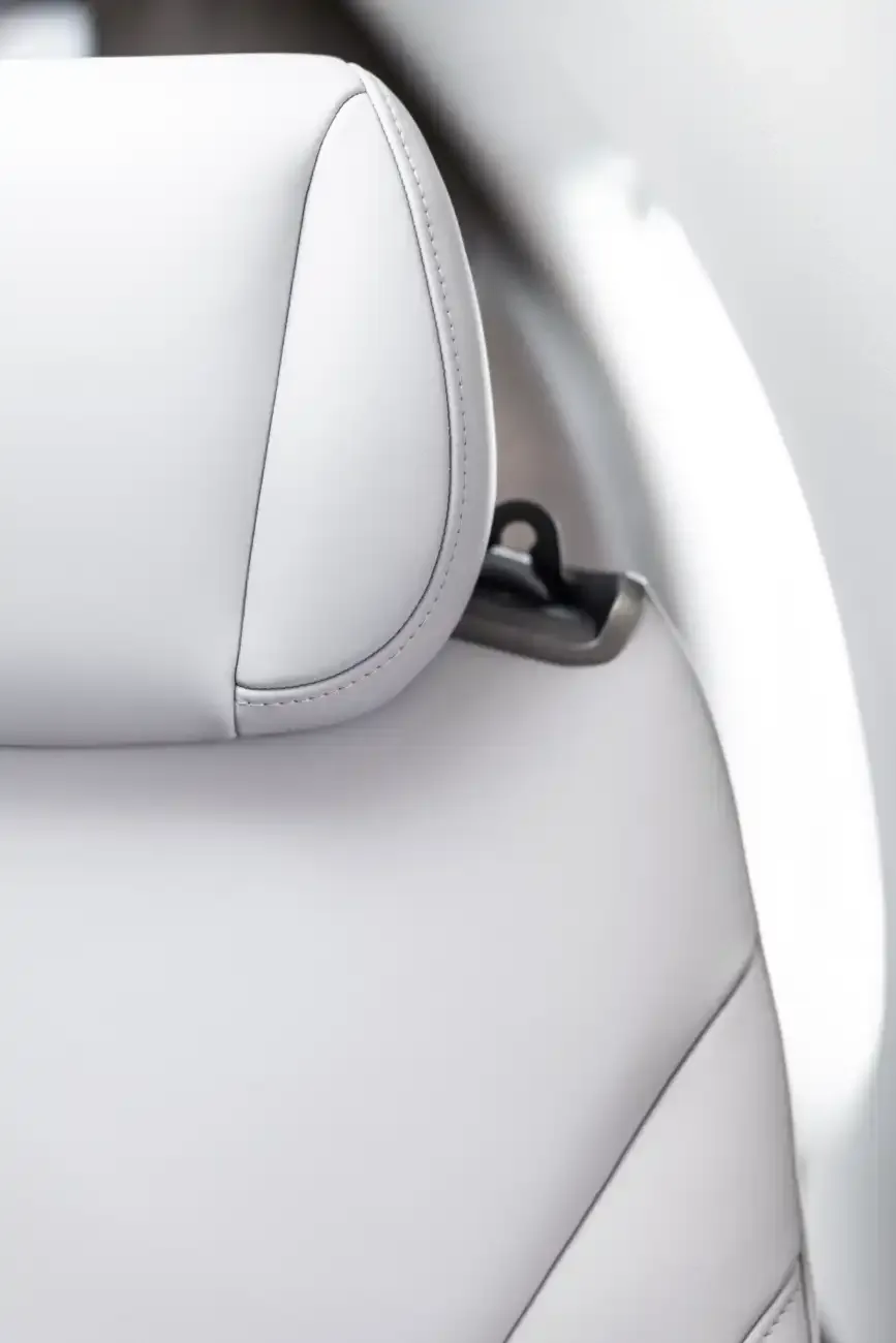 Close-up of the aircraft's interior showing a white leather seat headrest.