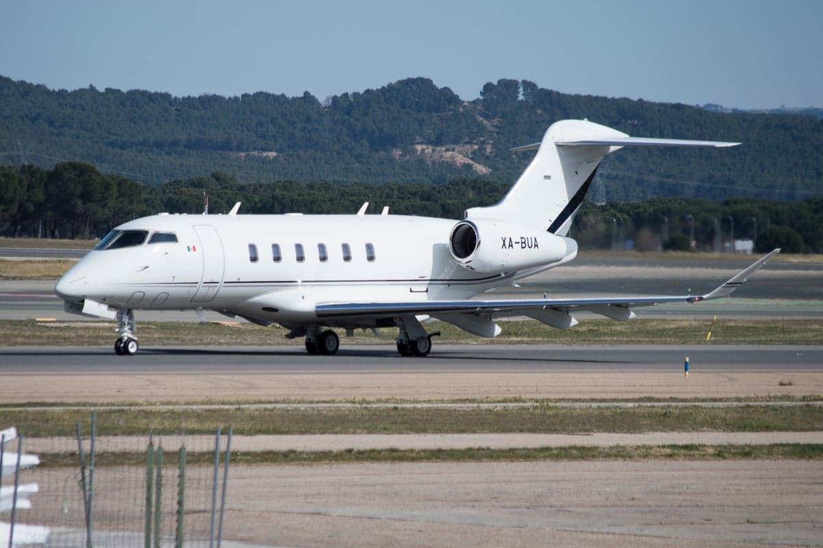 A white private jet with Mexican registration XA-BUA on the tarmac.