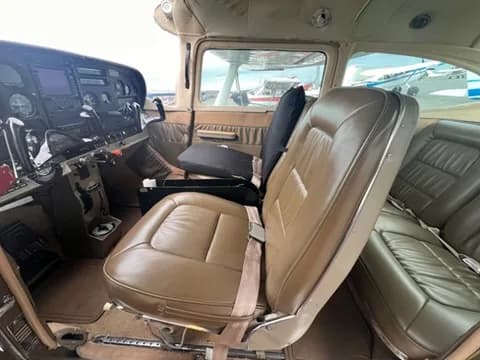 The tan leather front seats and part of the instrument panel inside a Cessna 182 aircraft.