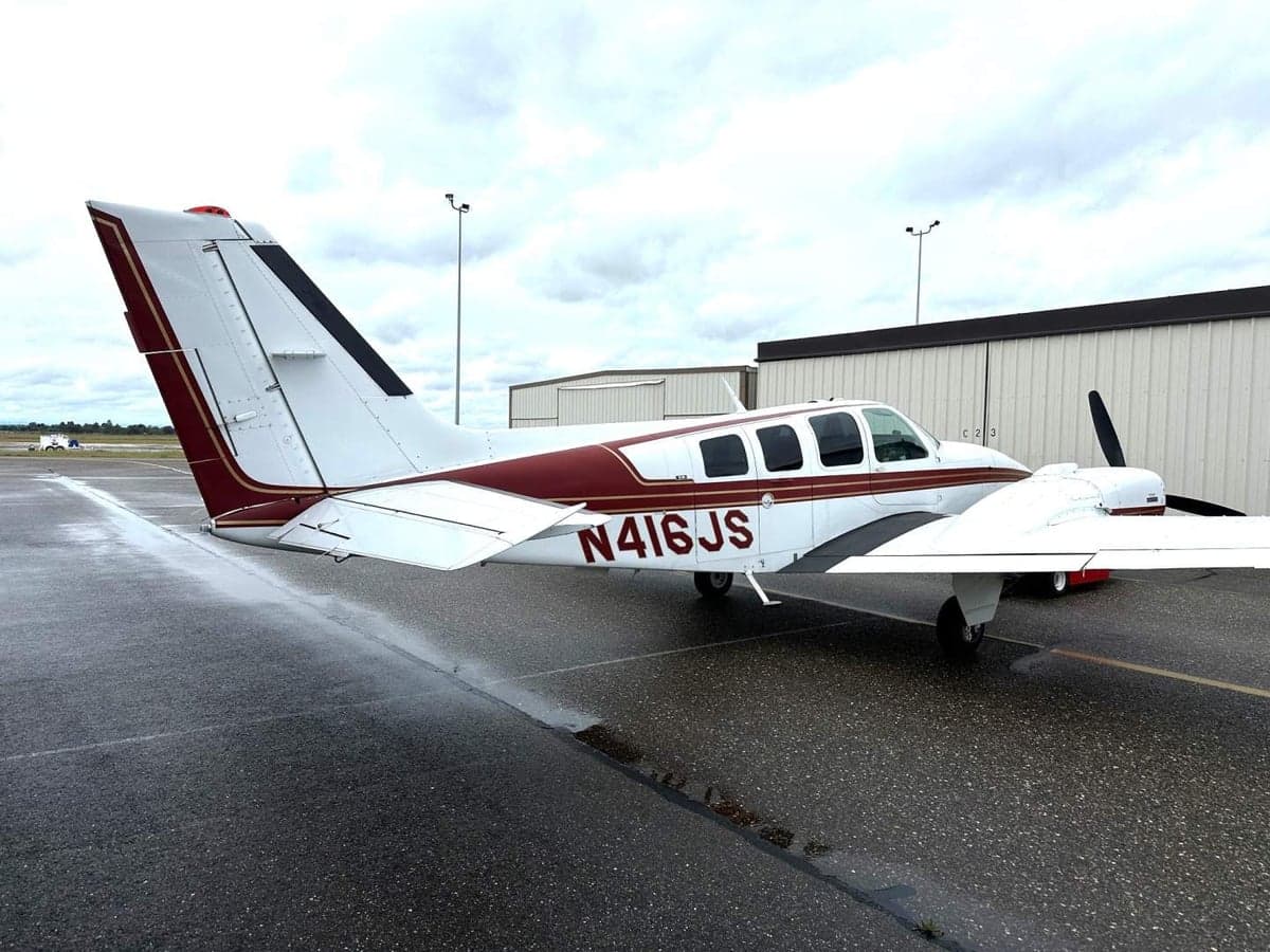 The tail of a Beechcraft Baron aircraft with registration number N416JS is visible.