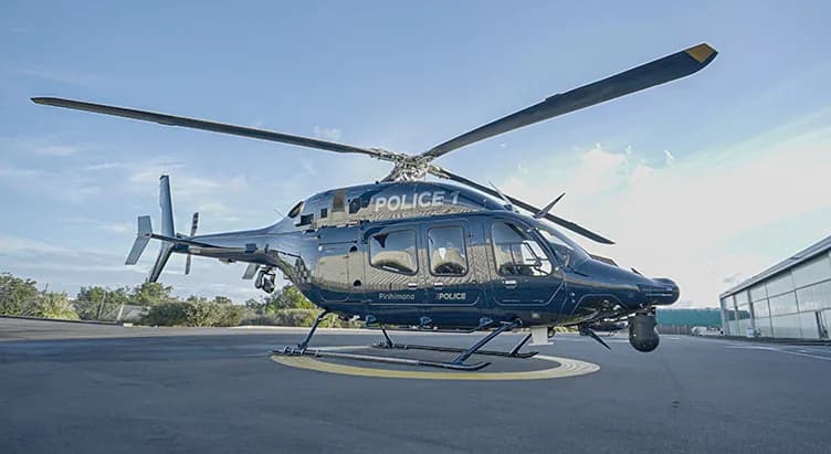 A black Bell 429 helicopter with 'Police' markings on a helipad.
