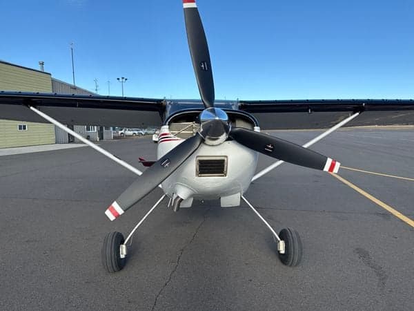Front view of a Cessna 185 Skywagon showing the propeller and landing gear.