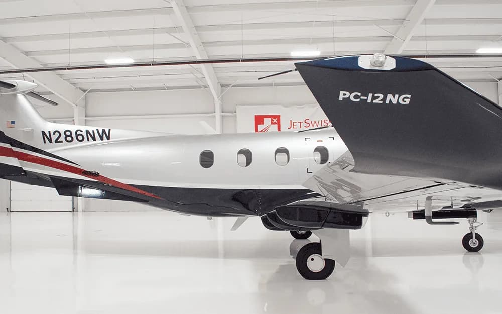 The tail section of a silver and black Pilatus PC-12 NG aircraft with registration N286NW, showing "PC-12 NG" on the tail.