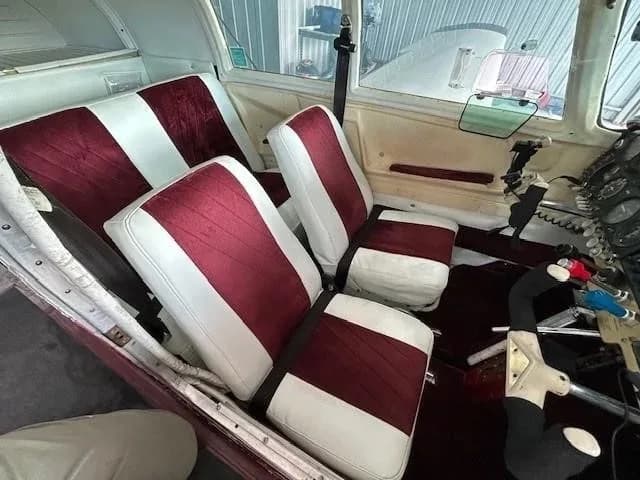 The interior cabin of the Mooney M20 Mark 21, featuring white and maroon striped seats.