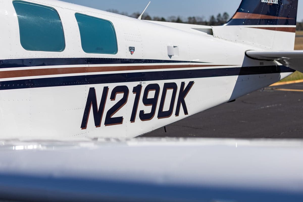 Close up of the side of the Beechcraft Bonanza N219DK showing the tail number and Beechcraft logo.
