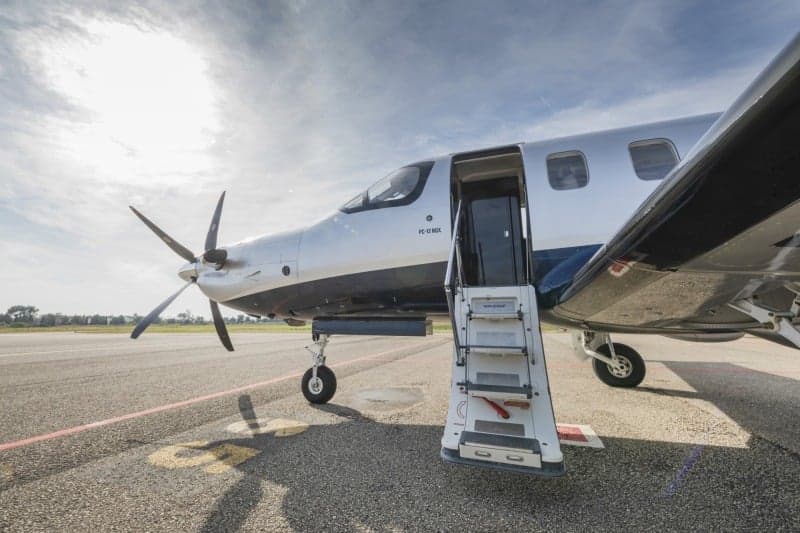 A close-up of a Pilatus PC-12 aircraft with registration LX-LLL parked on the tarmac.