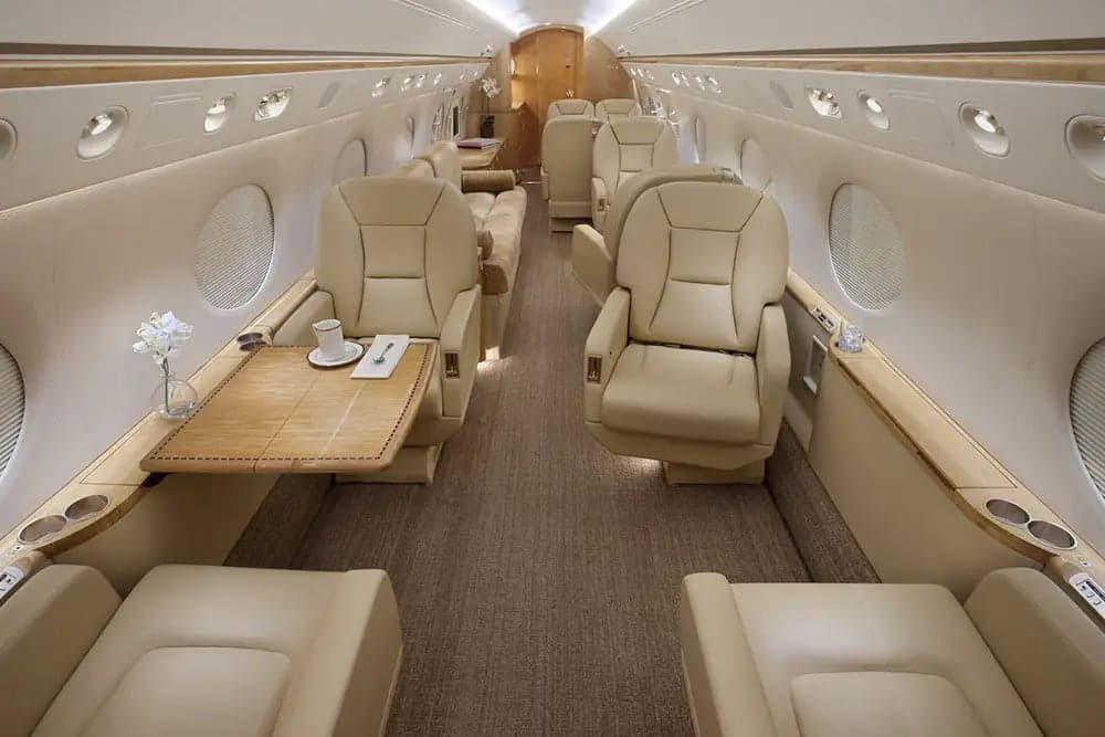 The interior of the aircraft features tan leather seats and wood accents.