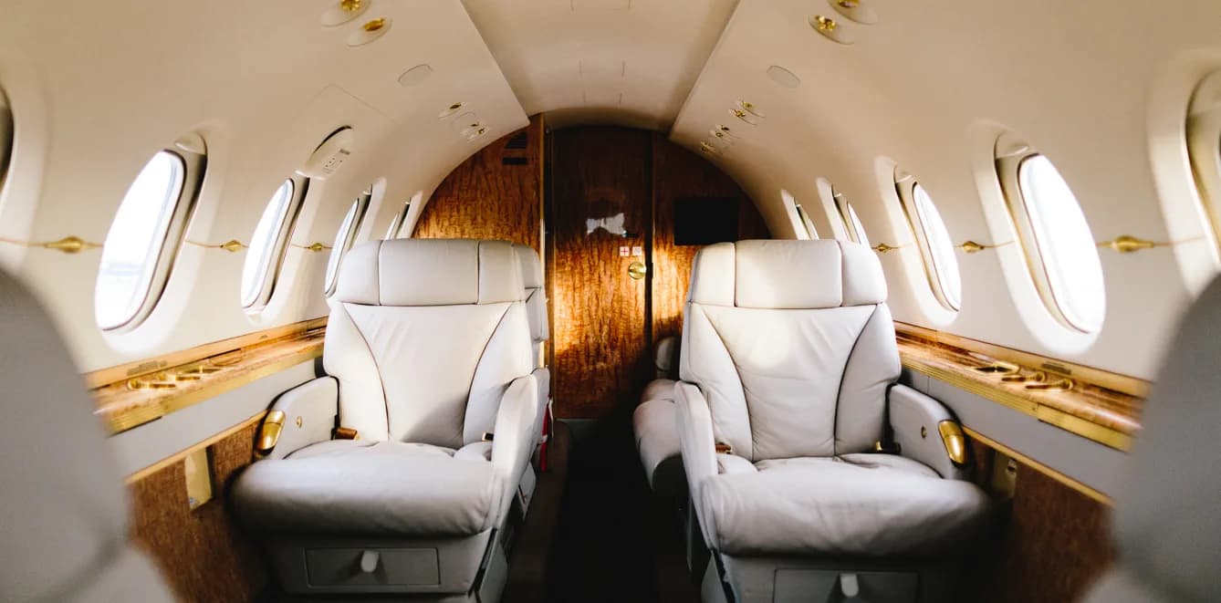 View of the aircraft's interior with leather seats and wood trim.