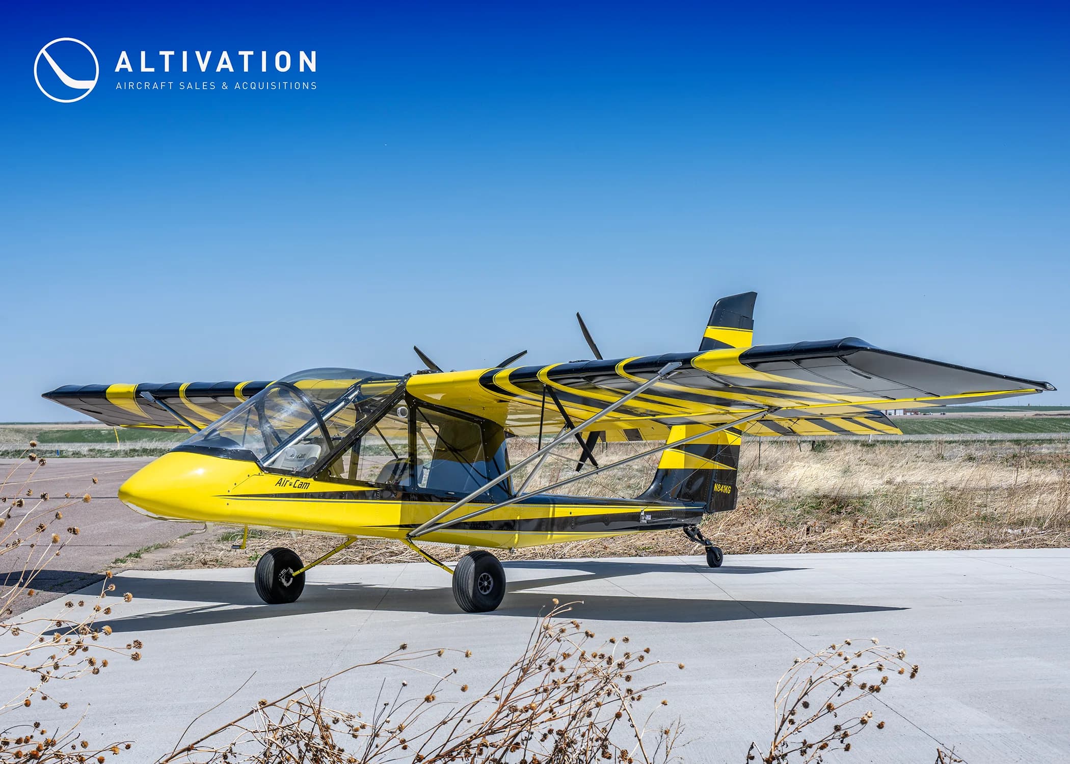 Yellow and black AirCam on the ground, side view.
