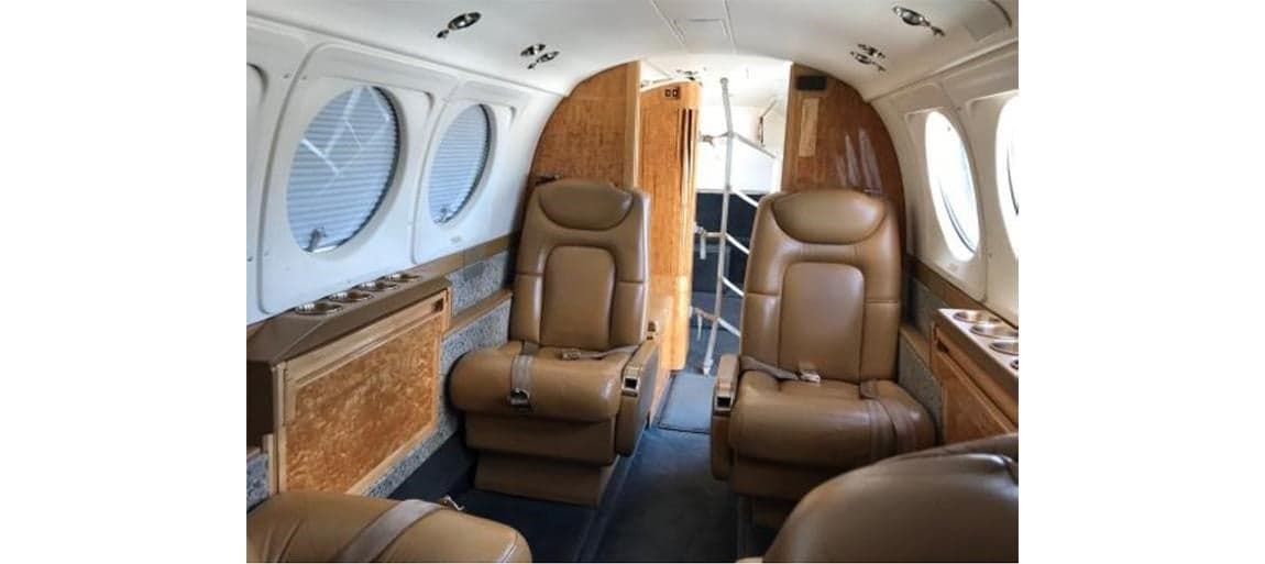 Interior view of the Beechcraft King Air cabin with leather seats and wood trim.