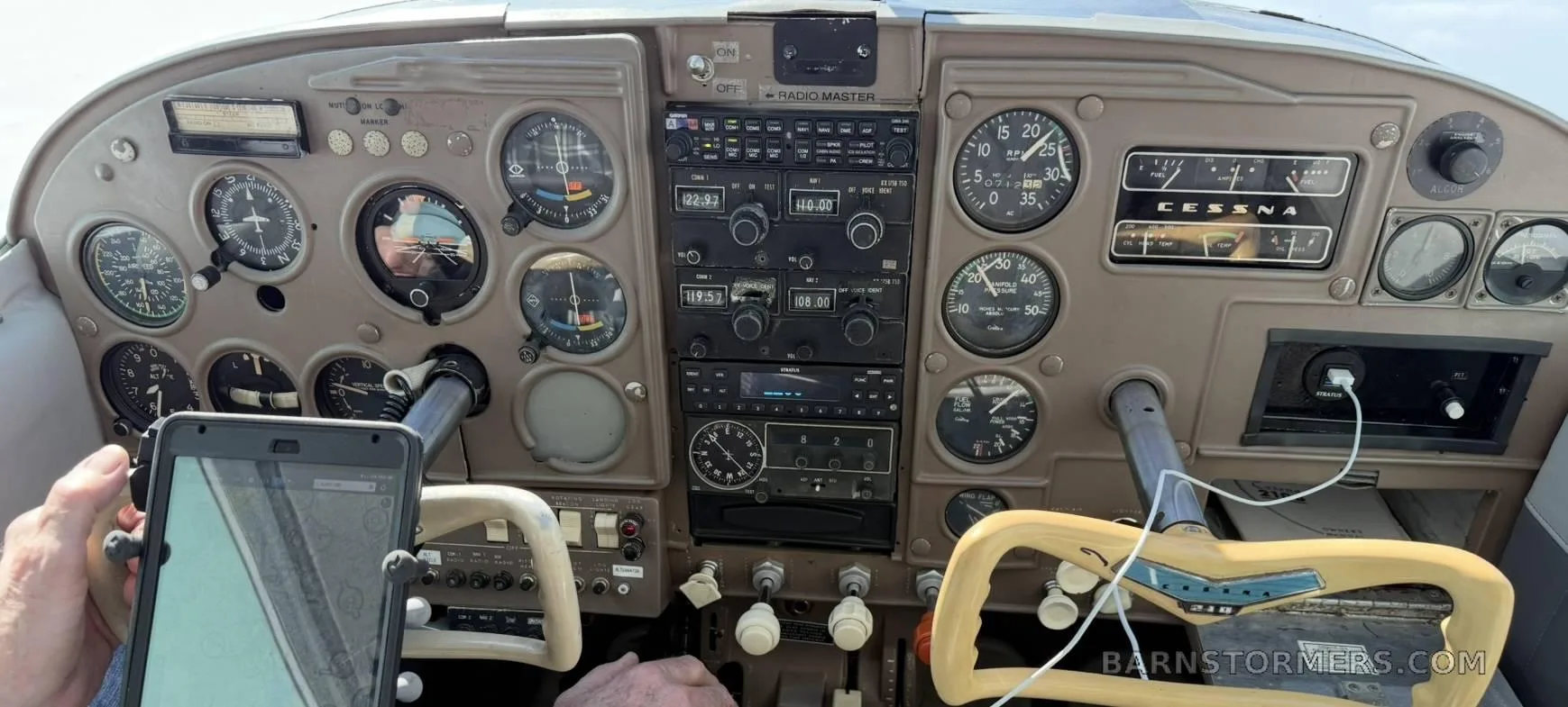 The instrument panel of a Cessna 210, featuring various gauges, radios, and control yokes.