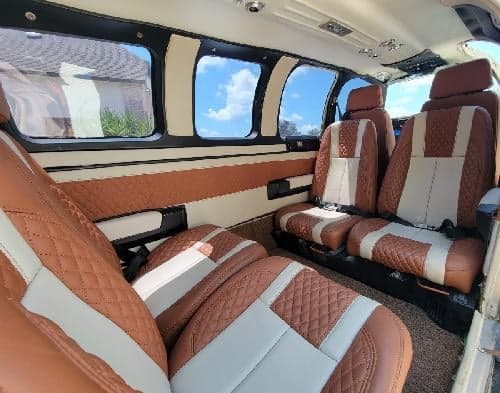 The interior of the aircraft features brown and white leather seats.