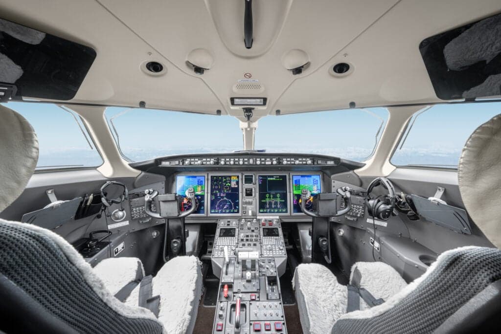 View of the aircraft cockpit with instrument panel and seats.