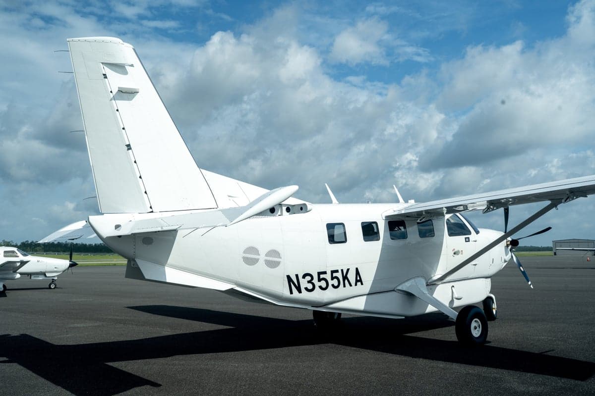 A white Quest Kodiak 100 aircraft, registration N355KA, viewed from the rear on an airfield.