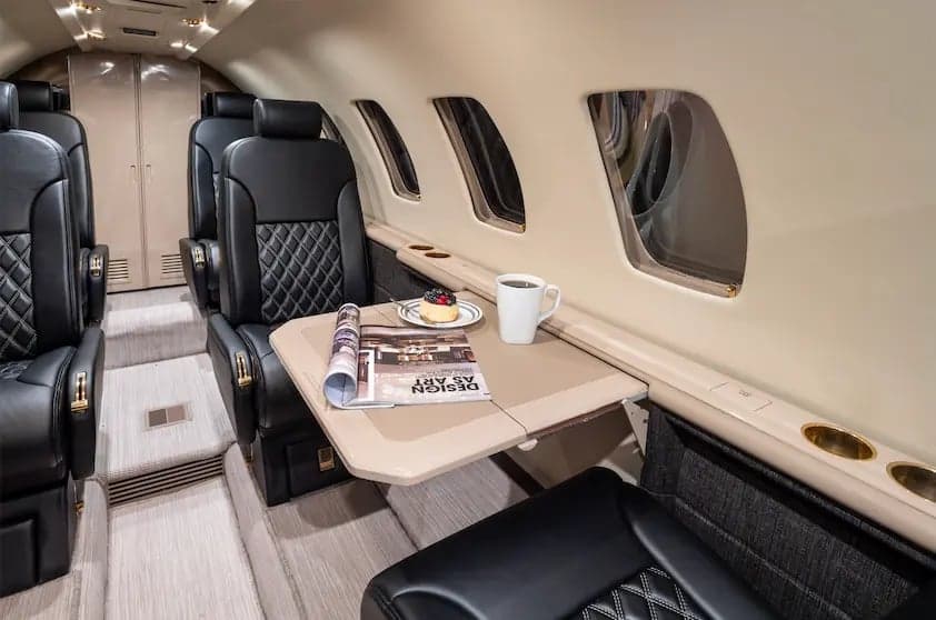 View of the interior cabin of the Cessna Citation Ultra, showing the seating arrangement and table.