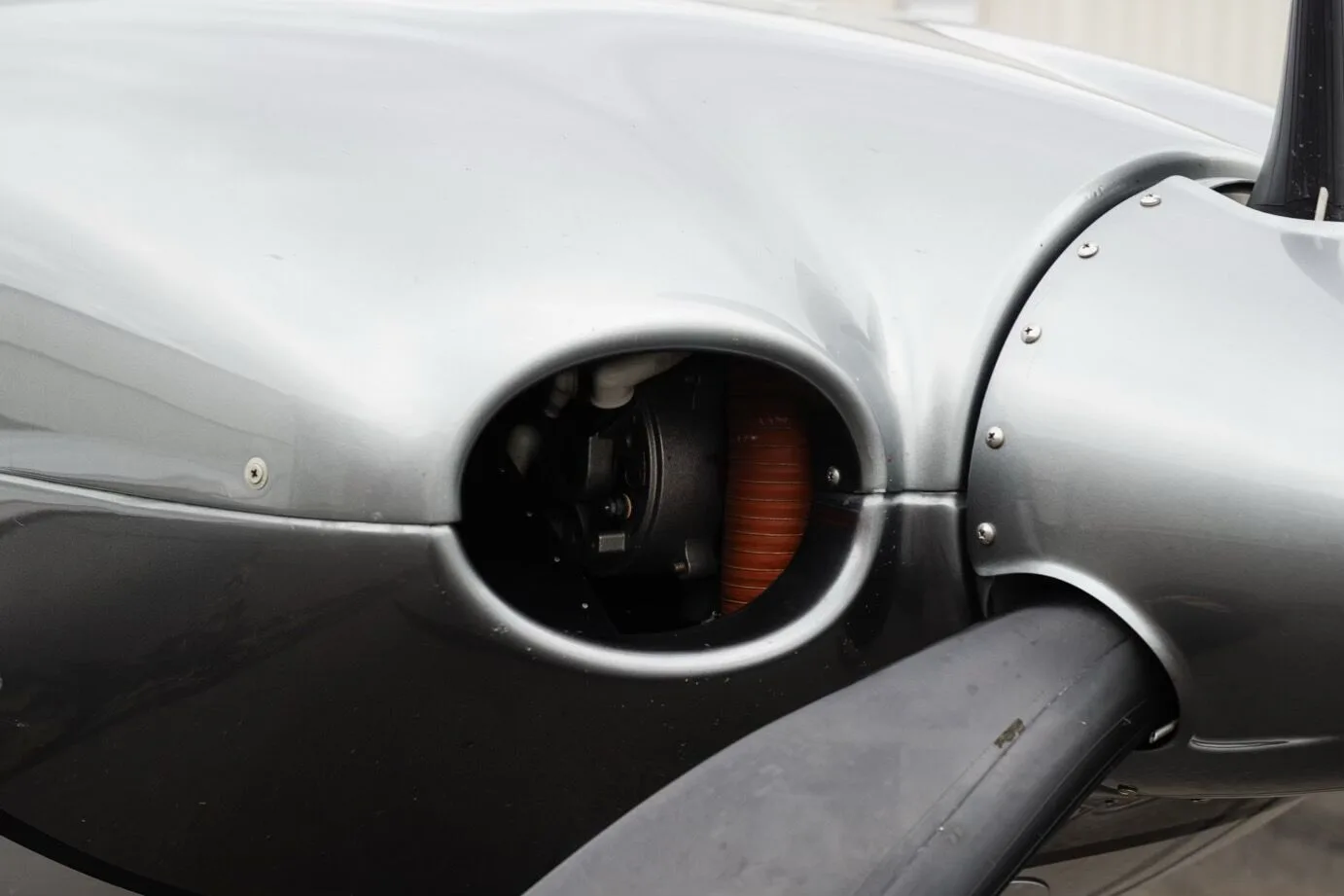 A close-up view of an engine air intake on the nose of the silver Cirrus SR22 GTS Platinum aircraft.