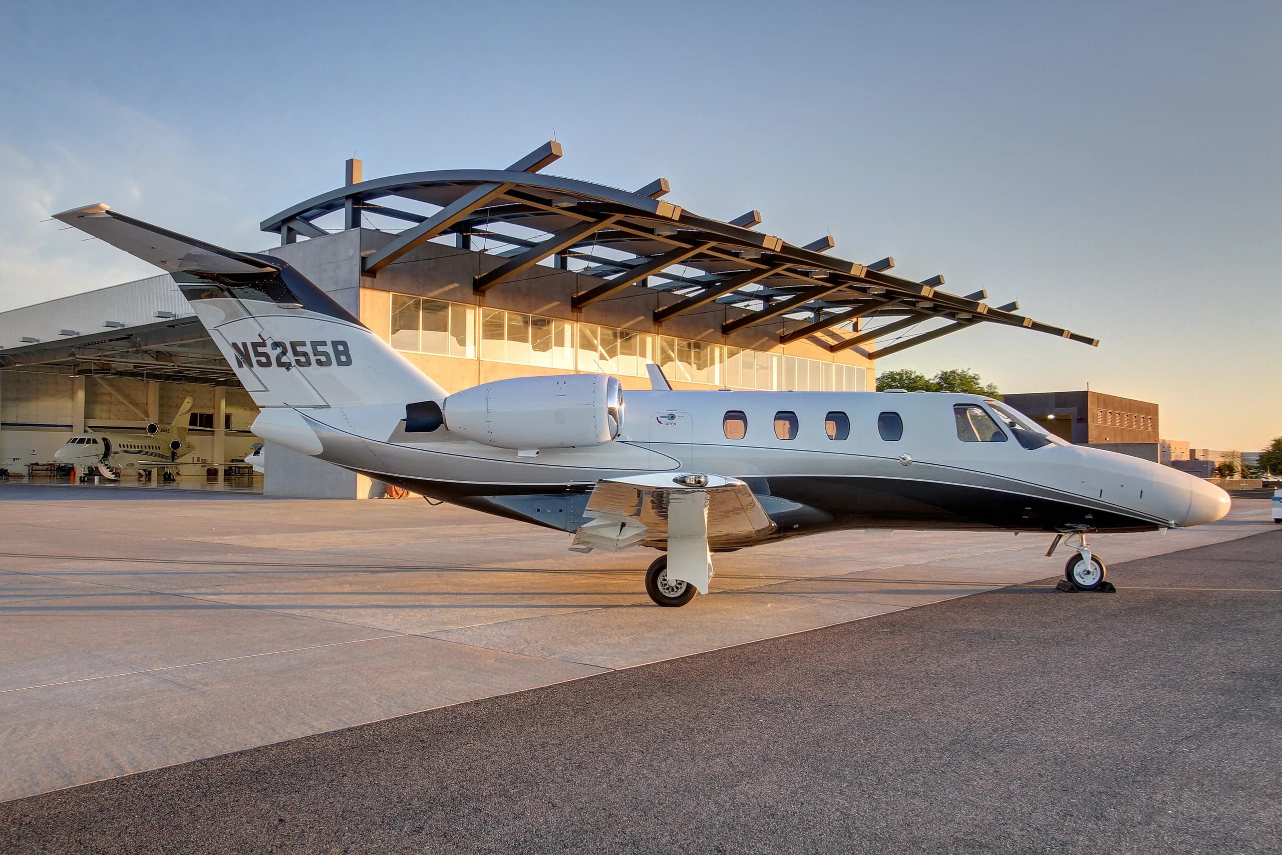 A Cessna Citation CJ3 aircraft with tail number N5255B is parked in front of a hangar.