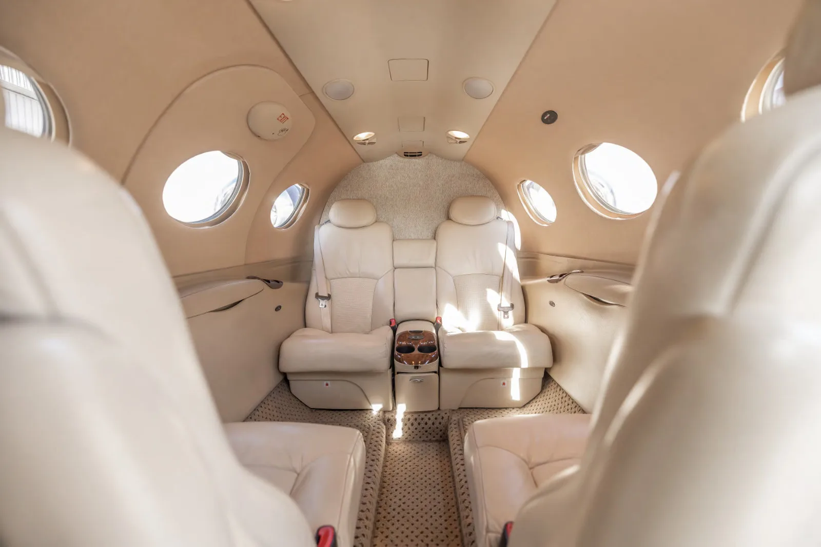 Interior view of a Cessna Citation Mustang cabin with cream-colored leather seats.