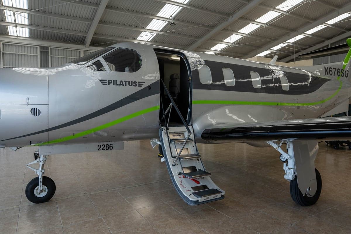 Close-up of the Pilatus PC-12 aircraft with registration N676SG, showing the open airstair door.