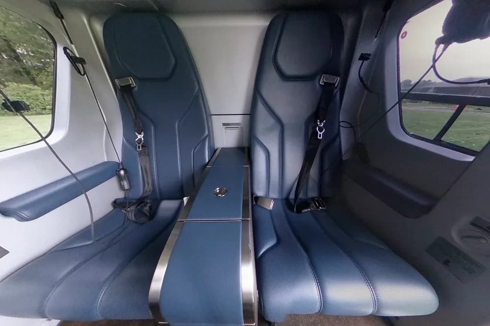 Interior view of the helicopter cabin with blue leather seats.