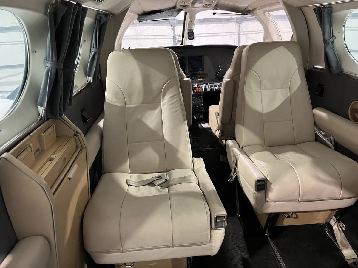 The aircraft's interior features cream-colored leather seats.