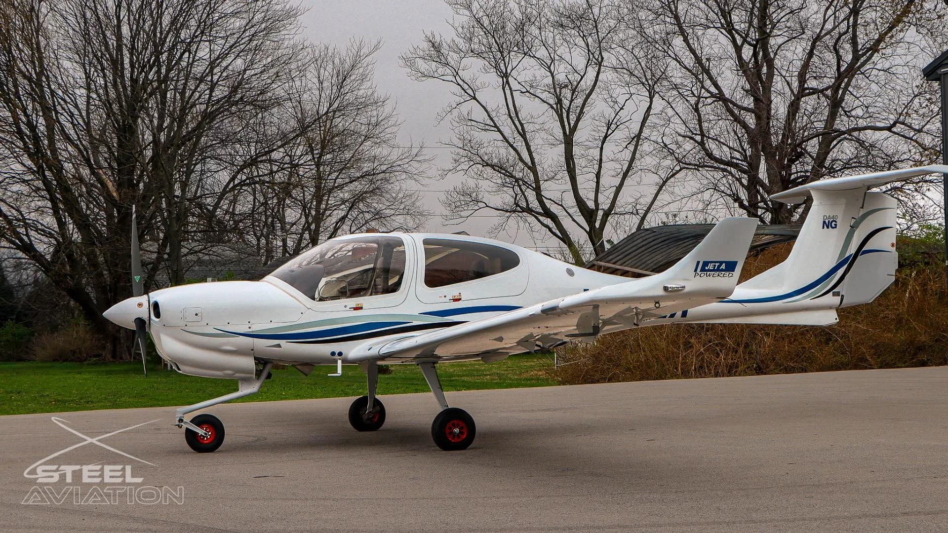 Side view of a white Diamond DA40 NG aircraft, N251LA, with blue and grey stripes and "JET A POWERED" on the tail.