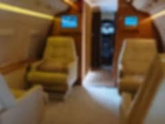 A blurry front view of the Challenger aircraft parked on the tarmac with the door open.