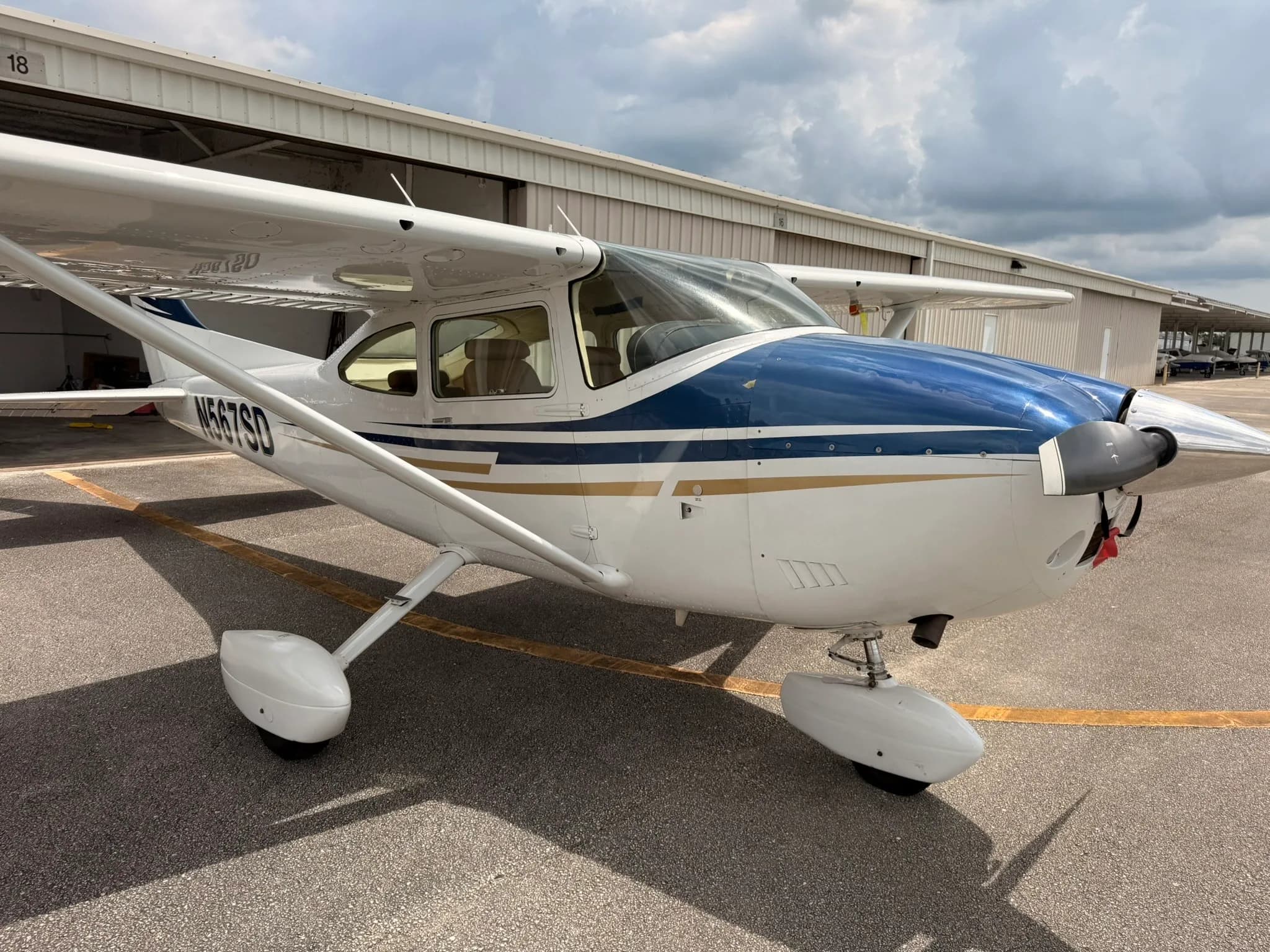 A front-right view of the Cessna Skylane N567SD, showing the aircraft parked on an asphalt ramp.