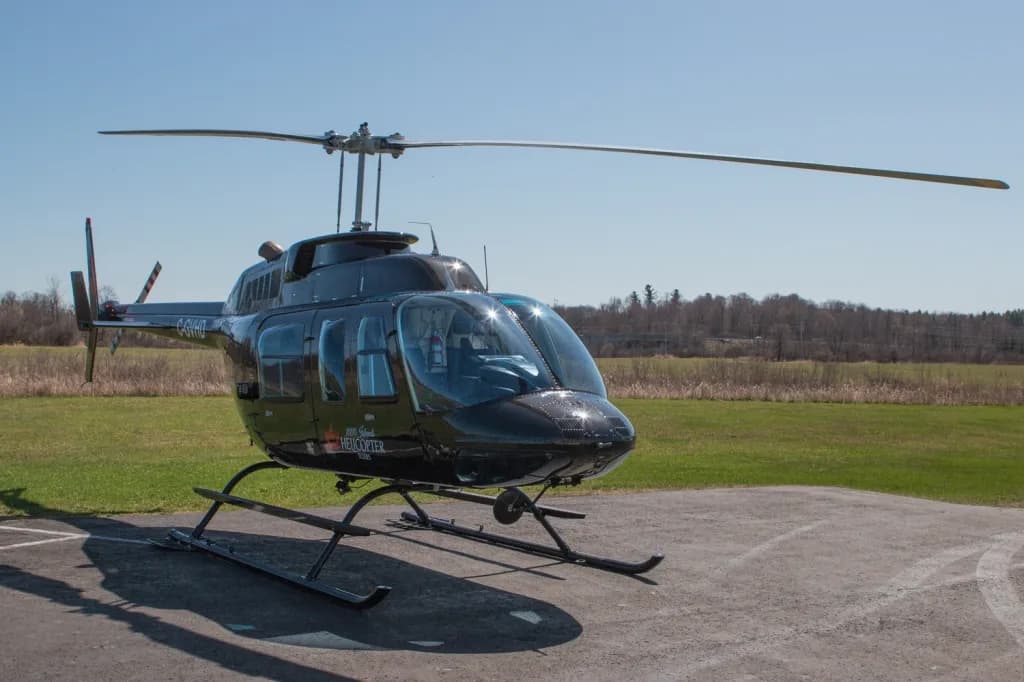 A black Bell 206 helicopter with registration C-GVHD is parked on a tarmac, viewed from the front-left.