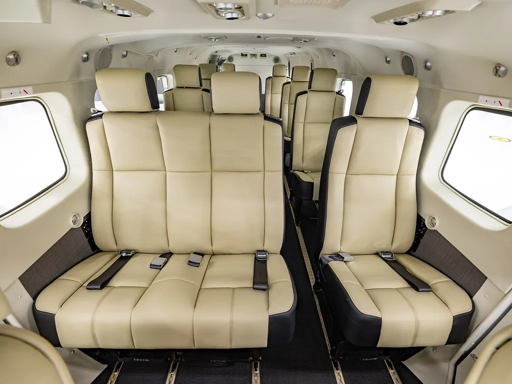 The interior cabin of the aircraft, featuring multiple rows of beige and black passenger seats.