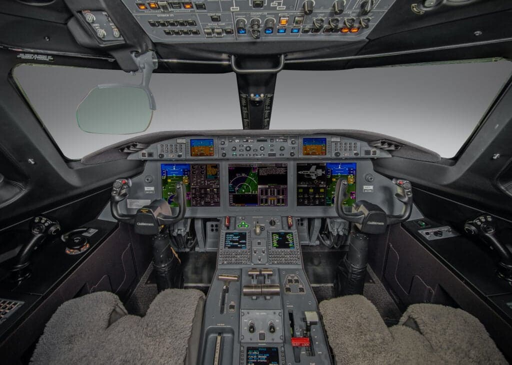 Close up of the engine and fuselage of a white and gold aircraft.