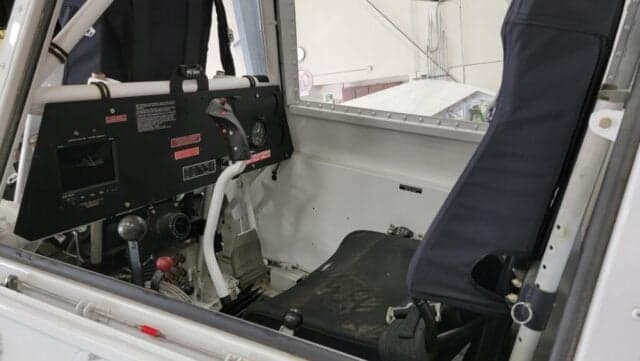 Interior view of the agricultural aircraft's cockpit, showing the instrument panel, controls, and pilot's seat.