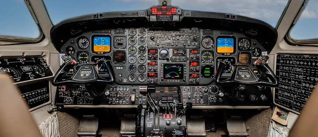 The detailed instrument panel of an aircraft cockpit, featuring multiple gauges, screens, and controls.