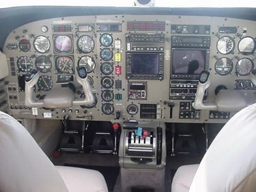 The cockpit of the aircraft features a full instrument panel and cream-colored seats.