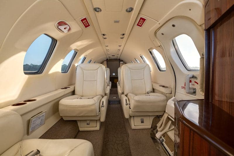 Interior view of the aircraft cabin with cream-colored leather seats.