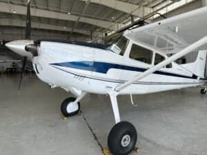Close-up of the front of a Cessna aircraft with a white and blue paint scheme.