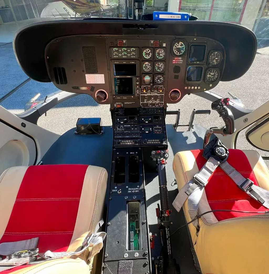 The helicopter cockpit features a detailed instrument panel, controls, and two pilot seats.