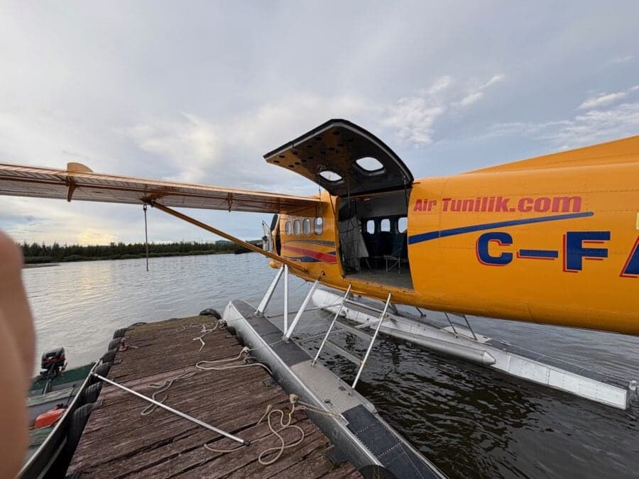 Yellow float plane docked at a pier with the door open.