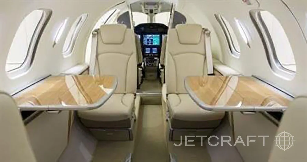 Interior view of the HondaJet cabin with tables and white leather seats.