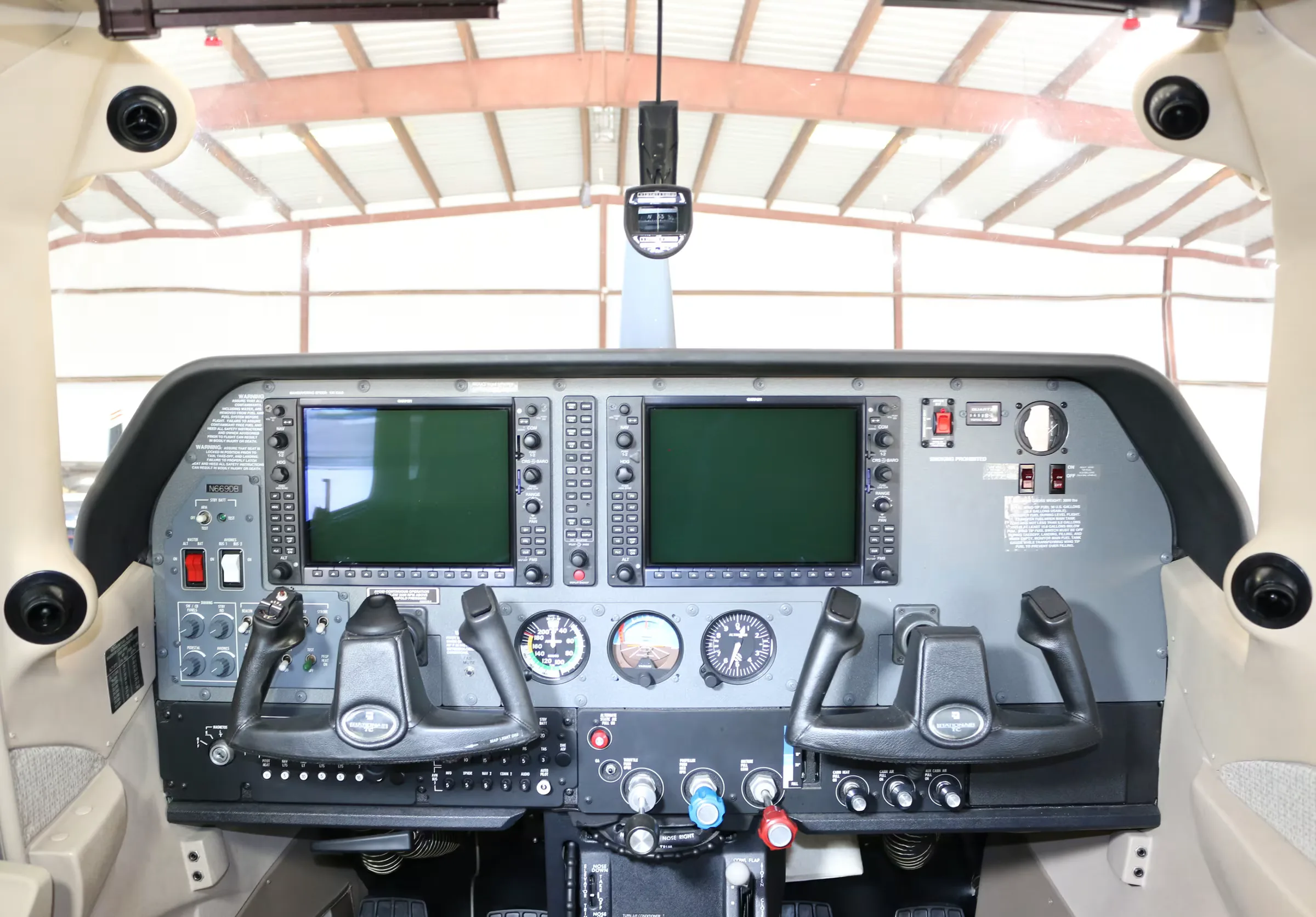 The cockpit of a Cessna Stationair TC, showing the instrument panel with two large display screens and dual yokes.