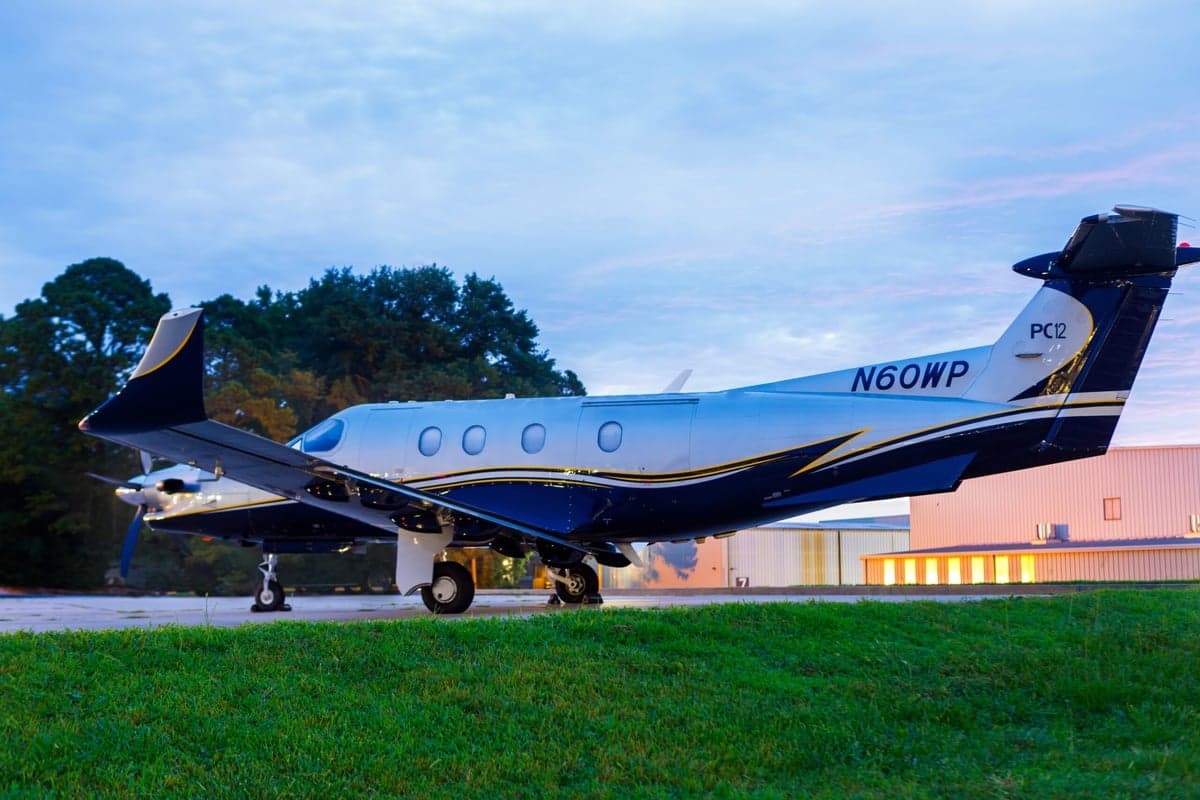 Side view of N60WP Pilatus PC-12 parked on the grass.