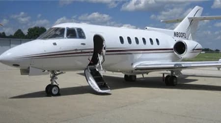 White jet with open door on the tarmac.