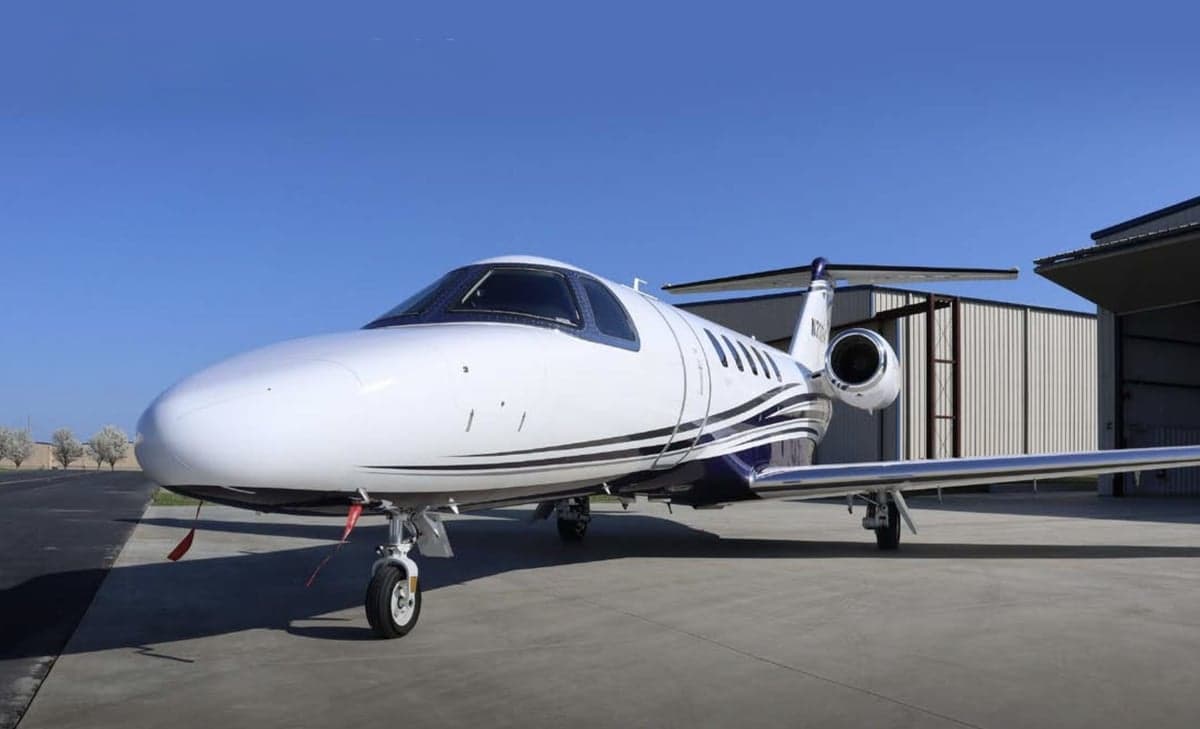 A white and blue Cessna Citation CJ3+ on the ramp.